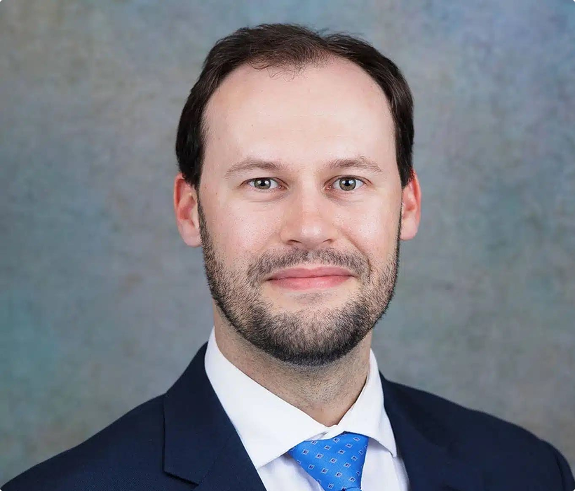 Professional headshot against gray background