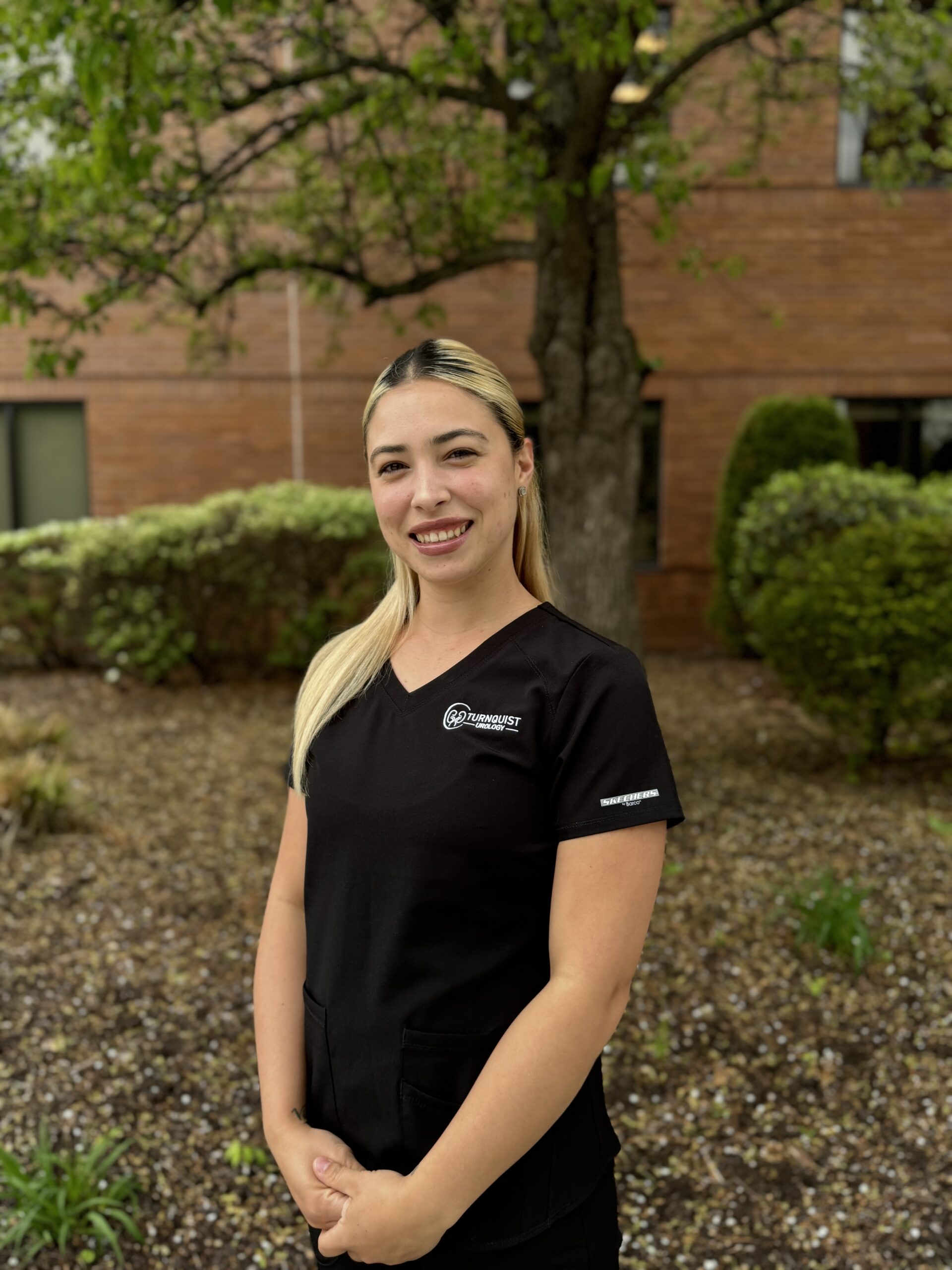 Smiling woman in black uniform outside